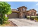 Single-story home with stone facade, two-car garage, and driveway at 2837 W Minton St, Phoenix, AZ 85041