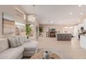Open-concept living room featuring a neutral color palette, light wood flooring, and a view of the kitchen at 3721 N 150Th Ct, Goodyear, AZ 85395