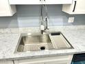 Stainless steel kitchen sink with modern faucet and a grid at 1230 N 84Th Pl, Scottsdale, AZ 85257