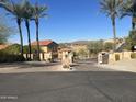 Gated community entrance with palm trees and mountain views at 12646 N 17Th Pl, Phoenix, AZ 85022