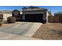 Single-story home with two-car garage, neutral exterior paint, and desert landscaping offers curb appeal at 268 S San Jose Ln, Casa Grande, AZ 85194