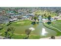 Aerial view of a community with a swimming pool, lake, golf course and community center at 10214 E Michigan Ave, Sun Lakes, AZ 85248