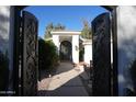Ornate entry gate and walkway leading to the front entrance of the house at 7214 E Royal Palm Rd, Scottsdale, AZ 85258