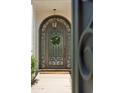 Elegant front door features decorative wrought iron, glass, and a welcoming wreath accent at 7214 E Royal Palm Rd, Scottsdale, AZ 85258