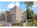 Tan stucco exterior, two-car garage, and desert landscaping at 9250 E Whitethorn Cir, Scottsdale, AZ 85266