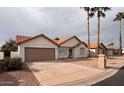 Inviting home with a two-car garage, an expansive driveway, and a xeriscaped front yard at 26630 S Pinewood Dr # 14, Sun Lakes, AZ 85248