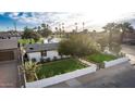An elevated front view of the property showing the private fence and grassy front yard at 1345 W Edgemont Ave, Phoenix, AZ 85007