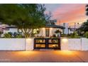 Beautiful exterior shot of updated home featuring modern black fence and fresh landscape at 1345 W Edgemont Ave, Phoenix, AZ 85007