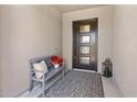 Inviting entryway featuring a decorative rug, a stylish bench, and a modern front door with glass panels at 2835 E Los Gatos Dr, Phoenix, AZ 85050