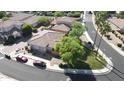 An aerial view showcases a single-Gathering home in a well-maintained neighborhood with mature trees at 13613 W Cypress St, Goodyear, AZ 85395