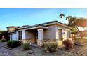 Tan colored stucco house with stone accents and a landscaped yard at 13613 W Cypress St, Goodyear, AZ 85395