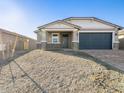 This home's exterior view features low-maintenance desert landscaping and a convenient two-car garage at 17737 W Elm St, Goodyear, AZ 85395
