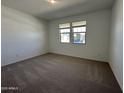 Sunlit bedroom with neutral carpet, creating a cozy and inviting atmosphere at 47267 W Mellen Ln, Maricopa, AZ 85139