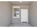 Covered porch featuring a white front door and a window to the left at 47267 W Mellen Ln, Maricopa, AZ 85139