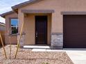 Close-up of the front entrance with stone accents and desert landscaping at 9120 N 174Th Ln, Waddell, AZ 85355