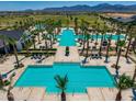 Expansive community pool area with cabanas, palm trees, lounge chairs, and well-maintained landscaping at 11899 N Spearfish St, Surprise, AZ 85388