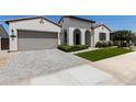 Inviting single-story home with a two-car garage, beautifully landscaped front yard, and a paved driveway at 11899 N Spearfish St, Surprise, AZ 85388