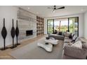 Stylish living room features a contemporary fireplace, built-in shelving, and large windows with backyard views at 6215 N Casa Blanca Dr, Paradise Valley, AZ 85253