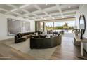 Bright living room with modern sofa and light hardwood floors offers stunning views of the pool at 6215 N Casa Blanca Dr, Paradise Valley, AZ 85253