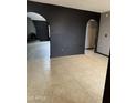 A spacious living room featuring neutral tile flooring and an arched entryway to a fireplace area at 815 W Kiva Ave, Mesa, AZ 85210