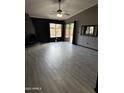 A spacious living room featuring tile floors, modern lighting, and sliding glass doors to the backyard at 815 W Kiva Ave, Mesa, AZ 85210