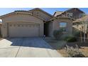 Beige house with a two-car garage and well-maintained landscaping at 12461 W Midway Ave, Glendale, AZ 85307