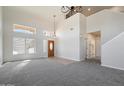 Bright and airy living room with a wooden front door, neutral carpet, and large windows at 19406 N 31St Way, Phoenix, AZ 85050