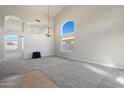 Open-concept living room with high ceilings, neutral carpet, and large windows providing ample natural light at 19406 N 31St Way, Phoenix, AZ 85050