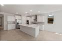 Modern kitchen featuring white cabinets, stainless steel appliances, and a spacious center island at 7674 W Cactus Wren Way, Florence, AZ 85132