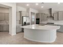 Open kitchen with stainless steel appliances, a large island, and gray cabinets at 7736 W Mockingbird Way, Florence, AZ 85132