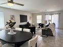 Bright living area featuring modern furnishings, a large TV, and a dining table with seating at 26722 N 174Th Ln, Surprise, AZ 85387
