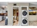 Bathroom and laundry area features tiled floors, stacked washer/dryer, and desert scene decor at 4600 N 68Th St # 313, Scottsdale, AZ 85251