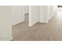 Bright hallway featuring wood-look flooring and white walls, offering a modern aesthetic at 22489 W Pontiac Dr, Surprise, AZ 85387