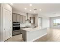 Modern kitchen features stainless steel appliances, subway tile backsplash, white quartz counters, and a large island at 24707 N 169Th Ave, Surprise, AZ 85387
