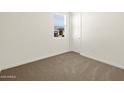 Cozy bedroom with neutral carpet, a window with blinds, and a closet at 37013 W La Paz St, Maricopa, AZ 85138