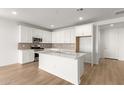 Open concept kitchen with island, white cabinets, and stainless steel appliances at 40548 W Wade Dr, Maricopa, AZ 85138