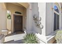 Inviting front porch featuring a decorative door, elegant wall art, and lush green plants at 14430 N Prickly Pear Ct, Fountain Hills, AZ 85268