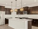 Modern kitchen featuring an island with pendant lights, sleek white countertops, and stainless steel appliances at 22507 W Pontiac Dr, Surprise, AZ 85387