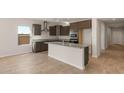 Modern kitchen with island, granite countertops, and dark wood cabinets at 17867 W Encinas Ln, Goodyear, AZ 85338