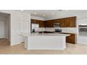 Open kitchen with an island, dark wood cabinets and quartz countertops at 17869 W Getty Dr, Goodyear, AZ 85338