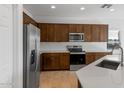 Modern kitchen featuring dark wood cabinets, stainless steel appliances, and white subway tile at 17869 W Getty Dr, Goodyear, AZ 85338