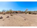 Tan stucco house with a long private driveway and desert landscaping at 22213 W Patton Rd, Wittmann, AZ 85361