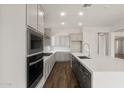 Modern kitchen with stainless steel appliances, gray cabinetry, an island, and wood-look tile flooring at 22500 E Orchard Ln, Queen Creek, AZ 85142