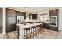 Spacious kitchen featuring dark cabinetry, a large center island with seating, and modern stainless steel appliances at 2121 W Sonoran Desert Dr # 29, Phoenix, AZ 85085
