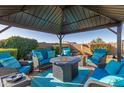Covered patio with comfortable seating and fire pit at 303 W Mammoth Cave Dr, San Tan Valley, AZ 85140