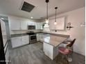 Bright kitchen with stainless steel appliances, gray countertops, white cabinets, and pendant lighting at 418 N Sirrine --, Mesa, AZ 85201