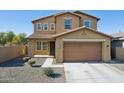 Two-story house with tan exterior, two-car garage, and desert landscaping at 6802 N 86Th Ln, Glendale, AZ 85305