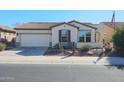 Single-story home with a two-car garage and desert landscaping at 17547 W Silver Fox Way, Goodyear, AZ 85338