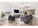 Bright living room featuring tiled floor, large windows, comfortable seating, and a ceiling fan at 3055 N Red Mountain Mtn # 95, Mesa, AZ 85207