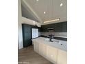 Contemporary kitchen featuring dark green cabinetry, white island, and high-end finishes at 6891 W Via Del Sol Dr, Glendale, AZ 85310